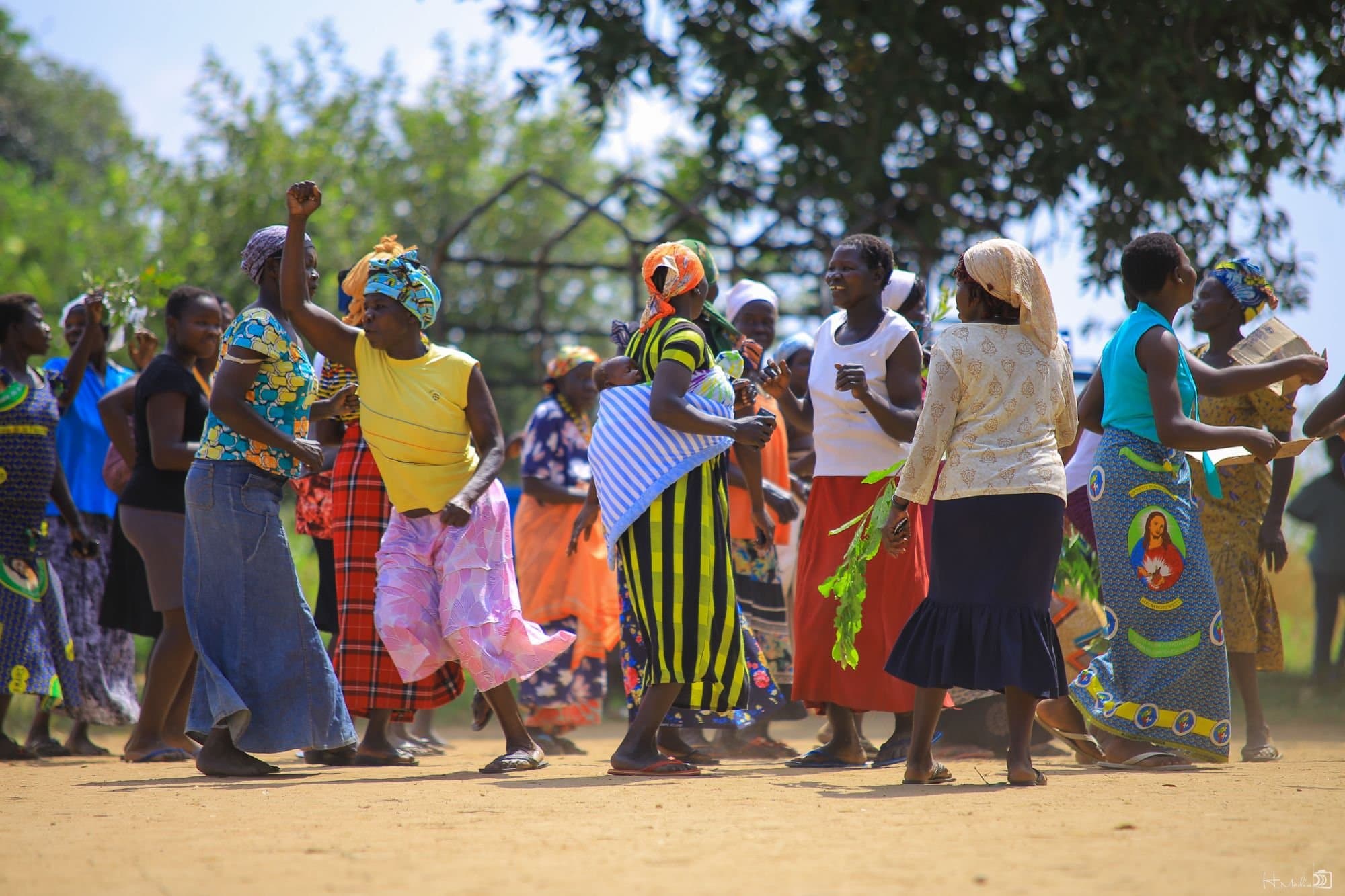 Women from a Kupanda Collective community gathering dancing together outdoors